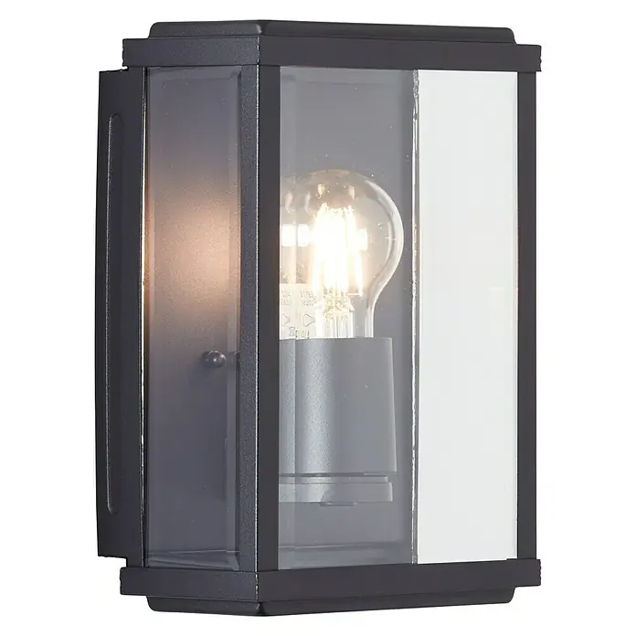 Brilliant Außenwandleuchte Gaia - 60 W, 12 x 16 x 25 cm, Schwarz, IP44 - Eine stilvolle schwarze Wandleuchte mit klarem Glas und einer warm leuchtenden Glühbirne, die eine gemütliche Atmosphäre schafft.