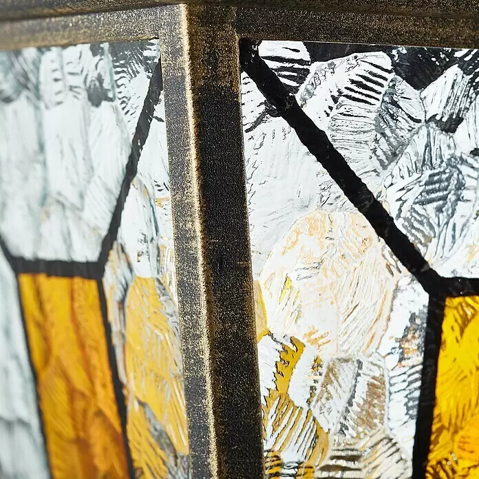 Brilliant Janel Außenwandleuchte - 20 W, 25,5 x 18 x 44,5 cm, Schwarz gold, IP44, Stehend - Nahaufnahme eines antikgoldenen Laternenrahmens mit strukturierten klaren und bernsteinfarbenen Glasscheiben.