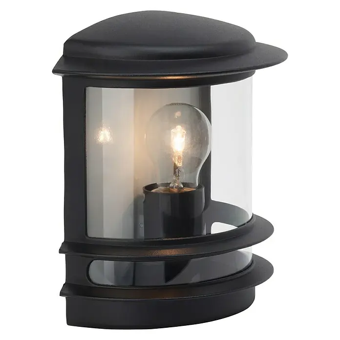 Brilliant Außenwandleuchte Hollywood - 60 W, 13 x 23,5 x 24 cm, Schwarz, IP44 - Nahaufnahme einer schwarzen Außenleuchte mit einer klaren Glühbirne im Inneren, die ein warmes Licht ausstrahlt. Die Leuchte hat ein modernes, abgerundetes Design.