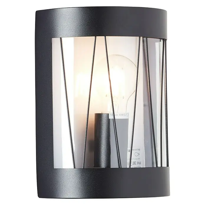 Brilliant Reed Außenwandleuchte - 40 W, 10,5 x 18,2 x 23,6 cm, Schwarz matt, IP44 - Nahaufnahme einer modernen schwarzen Wandleuchte mit einem klaren, zylindrischen Schirm und dekorativen Streben.