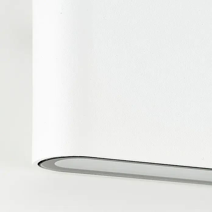 Brilliant LED-Außenwandleuchte Welbie - 7 W, 2,9 x 11,5 x 9 cm, Weiß, IP54 - Nahaufnahme eines eleganten, weißen Produkts mit einer schmalen, dunklen Kontur, das minimalistisches Design und hochwertige Verarbeitung vereint.