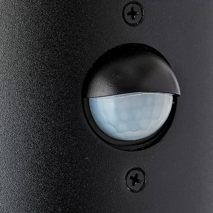 Brilliant Sensor-Außenleuchte Sergioro - 20 W, 12,5 x 9 x 20,2 cm, Schwarz matt, IP44 - Nahaufnahme eines schwarzen Bewegungsmelders mit heller, segmentierter Fresnellinse, montiert mit zwei Schrauben.