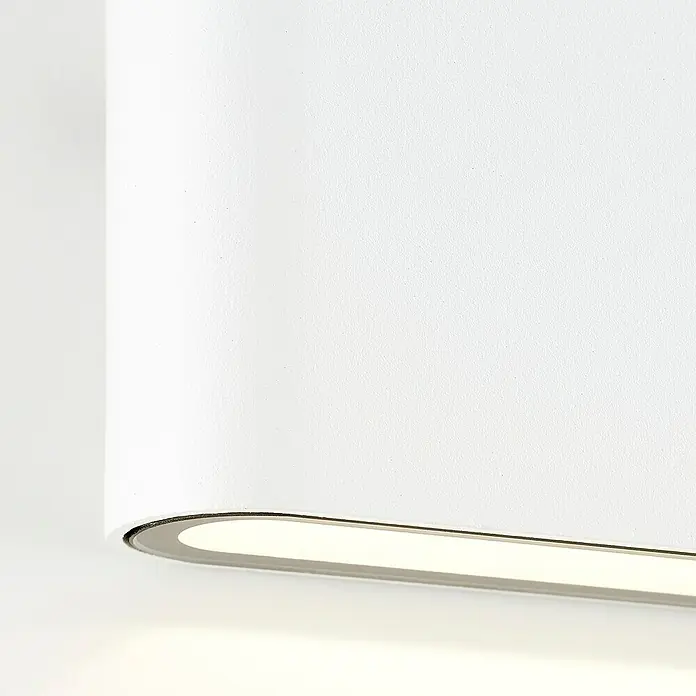 Brilliant LED-Außenwandleuchte Welbie - 7 W, 2,9 x 11,5 x 9 cm, Weiß, IP54 - Nahaufnahme einer modernen, weißen Wandleuchte, die ein weiches, indirektes Licht ausstrahlt. Das schlichte Design integriert sich nahtlos in jede Einrichtung.