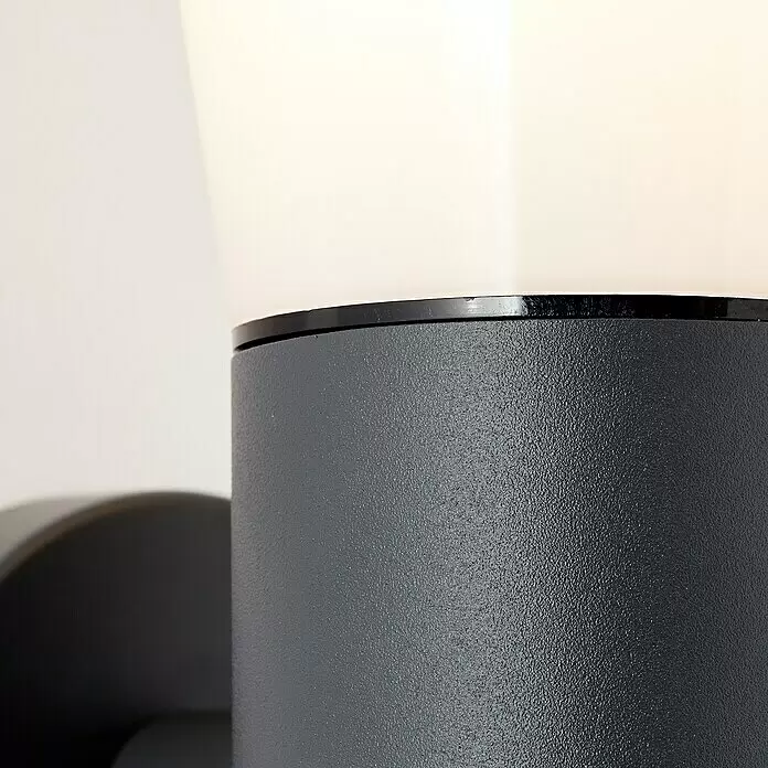 Brilliant Sensor-Außenleuchte Cliffi - 20 W, 16 x 10,5 x 24 cm, Anthrazit, IP44 - Dunkelgraue, texturierte zylindrische Lampe mit transluzentem weißem Schirm und schwarzem Ring.