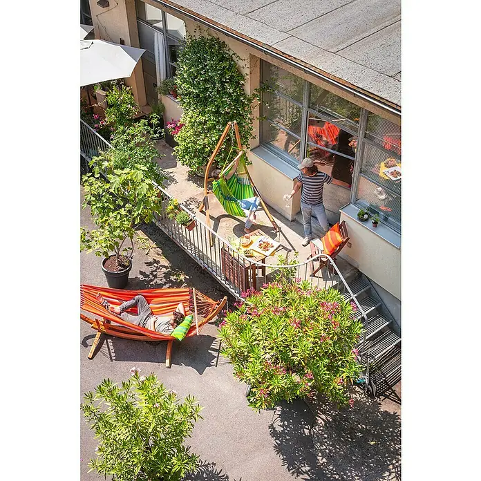 La Siesta Hängesessel Domingo Basic - Lime - Ein sonniger Innenhof mit zwei Hängematten und einem Hängesessel, ideal zum Entspannen und Genießen des schönen Wetters.