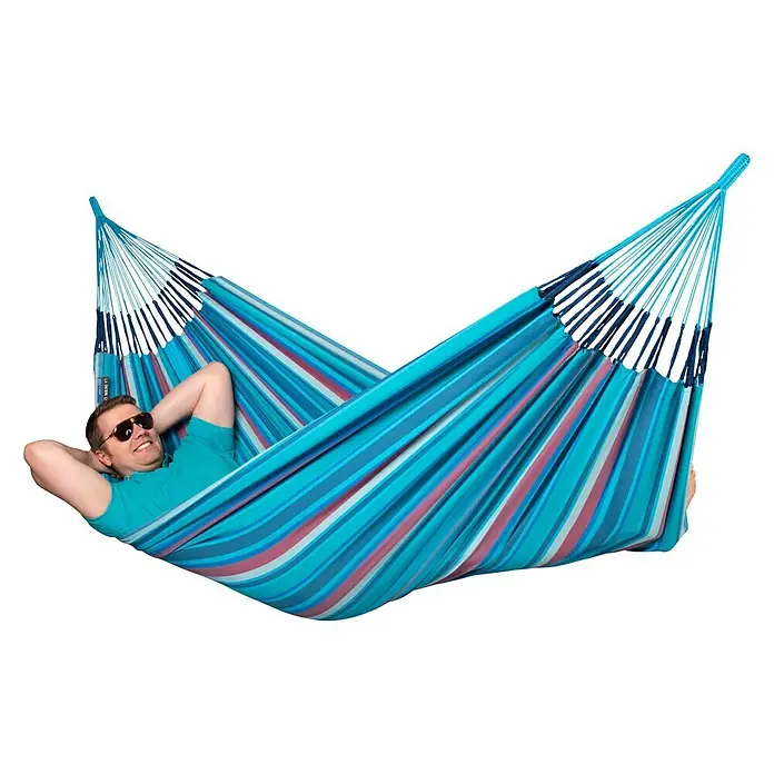 La Siesta Hängematte Brisa - L x B: 350 x 160 cm, Wave - Mann entspannt in einer gestreiften Hängematte. Die Hängematte ist blau mit rosa und weißen Streifen.