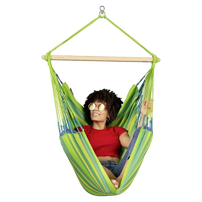 La Siesta Hängesessel Domingo Basic - Lime - Frau entspannt in Hängeinsel Hängesessel mit hellgrünen und gelben Streifen. Der Hängesessel ist aus Baumwolle und hat eine Holzstange.
