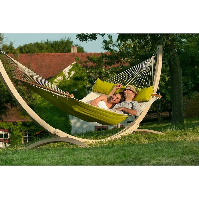 La Siesta Doppelstabhängematte Alabama - L x B: 400 x 140 cm, Avocado - Ein Paar entspannt sich in einer freistehenden Hängematte mit Holzgestell, umgeben von üppigem Grün. Komfort und Entspannung pur!