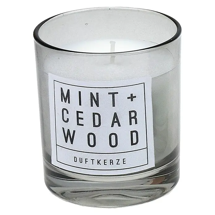 Duftkerze - Im Glas, Mint und Cedarwood, Ø x H: 6,5 x 7,9 cm - Nahaufnahme einer Duftkerze im Glas mit dem Etikett "Mint + Cedar Wood Duftkerze", die eine frische und holzige Atmosphäre verspricht.