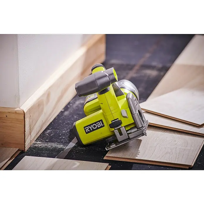 Ryobi ONE+ Akku-Tauchsäge R18MMS-0 - 18 V, Ohne Akku, Leerlaufdrehzahl: 4.250 U/min - Das Bild zeigt eine Ryobi-Säge, die auf einem Laminatboden platziert ist, neben einer Fußleiste, die gerade installiert wird.