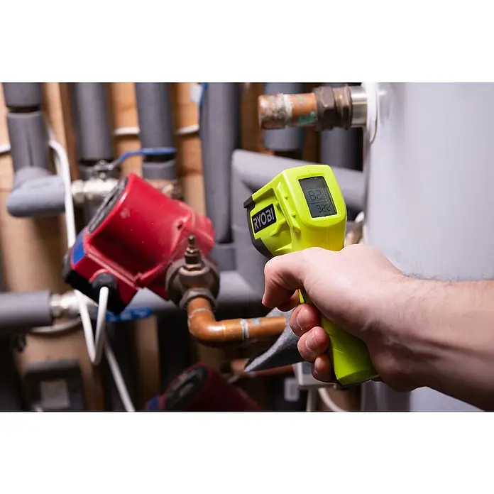 Ryobi Infrarot-Thermometer RBIRT08 - Messbereich: -50 °C bis +500 °C - Nahaufnahme eines Mannes, der mit einem gelben Ryobi Infrarot-Thermometer die Temperatur eines Heizkörpers misst.