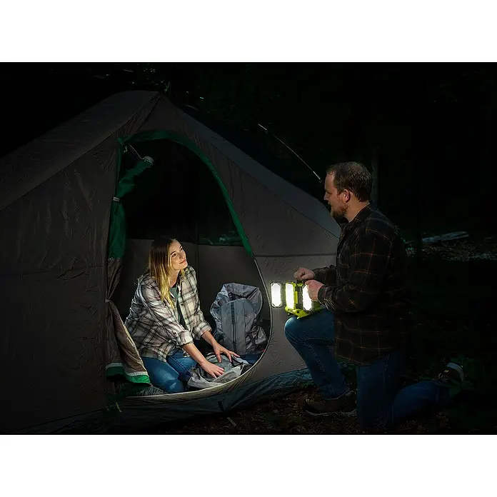 Ryobi ONE+ LED-Akkustrahler RLP18-0 - 18 V, Ohne Akku, 3.000 lm - Ein Paar beim Camping mit einer LED-Campinglampe, die hell leuchtet. Ideal für Campingausflüge und nächtliche Abenteuer in der Natur.
