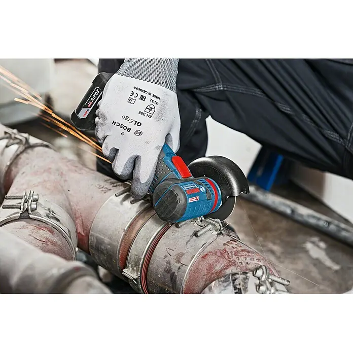 Bosch Professional Akku-Winkelschleifer GWS 12V-76 L-Boxx - Ohne Akku, Durchmesser Scheibe: 76 mm, 19.500 U/min - Nahaufnahme eines Bosch Akku-Winkelschleifers beim Einsatz an einer Rohrleitung, Funken fliegen.