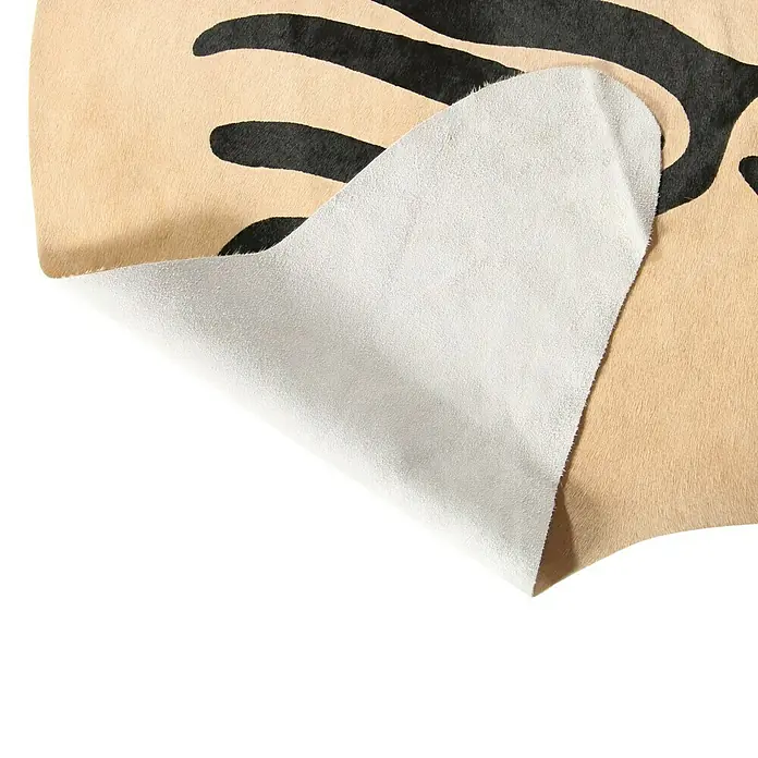 Esbeco Kuhfell - 100 % Echtfell, Zebra - Nahaufnahme einer stilvollen Kuhfellmatte mit einem einzigartigen Zebramuster, die die hochwertige Verarbeitung und das exklusive Design hervorhebt.