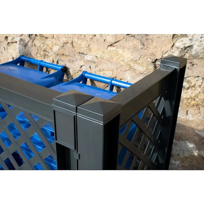 KHW Mülltonnenbox Verkleidung - 119 x 49 x 100 cm, Kunststoff, Anthrazit - Nahaufnahme einer grauen Mülltonnenbox mit blauen Mülltonnen im Hintergrund, die eine stilvolle und praktische Lösung für die Müllentsorgung bietet.