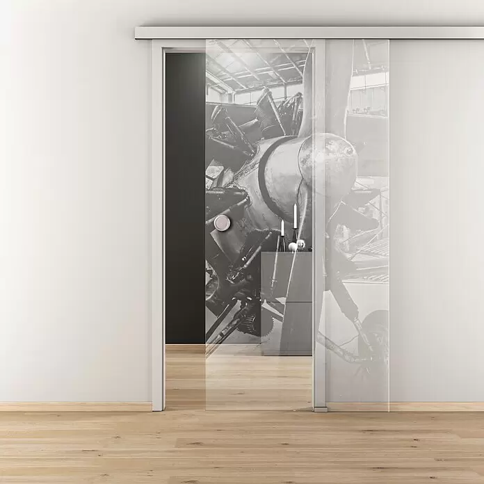 Diamond Doors Glasschiebetür 619 - 935 x 2.058 mm, Einscheibensicherheitsglas (ESG), Klarglas - Glastür zum Schieben mit Schwarz-Weiß-Druck eines Flugzeugmotors und rundem Griff, teilweise geöffnet im modernen Interieur.