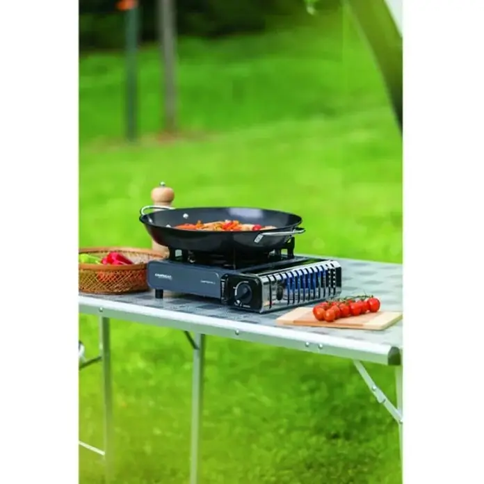 Campingaz Hornillo de gas Bistro 3 - L x An x Al: 36 x 32 x 13,7 cm, 2,2 W, Número de quemadores: 1 ud. - Una estufa de camping con un wok e ingredientes sobre una mesa al aire libre. La estufa es de la marca Campingaz.
