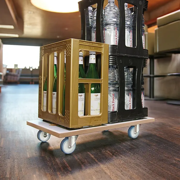 Wagner System Transportroller MM 1318 - L x B x H: 575 x 300 x 100 mm, Traglast: 200 kg, Holz - Ein Rollbrett mit einem Kasten Müller-Thurgau Wein und einem Kasten Black Forest Mineralwasser auf einem dunklen Holzboden.