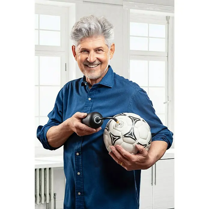 Wiha Akku-Luftpumpe - 6 -tlg., Max. Druck: 10 bar - Ein Mann mittleren Alters pumpt einen Fußball mit einer schwarzen Ballpumpe vor einem hellen Hintergrund auf.