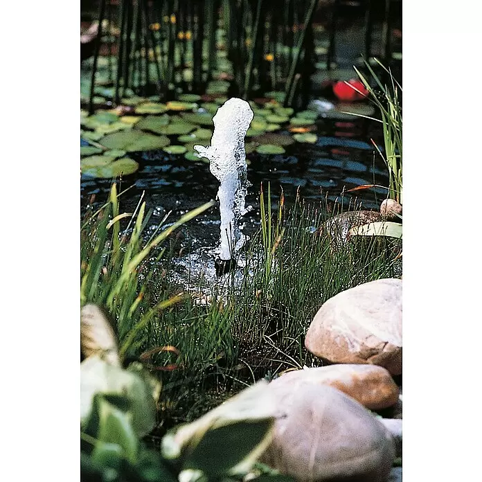 Ubbink Wasserspielpumpe Xtra 3900 - 100 W - Ein Wasserstrahl aus einem Springbrunnen in einem Teich, umgeben von grünem Schilf und Steinen.