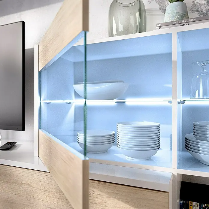 Dekit Conjunto mueble de salón Uma - Blanco Brillo/Natural, 3 pzs. - Una vitrina moderna con iluminación elegante exhibe platos y objetos decorativos con estilo.