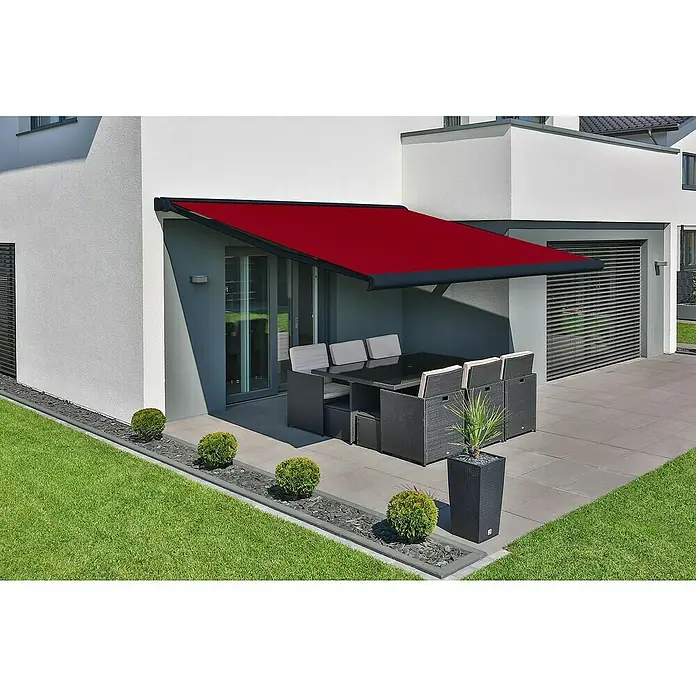 Deyo Limassol Vollkassettenmarkise - Rot, Farbe Gestell: Anthrazitgrau Feinstruktur, Breite: 4 m, Ausfall: 3,5 m - Ein modernes Haus mit einer stilvollen, roten Markise über einer Terrasse mit Gartenmöbeln, die Schatten spendet und das Außendesign ergänzt.