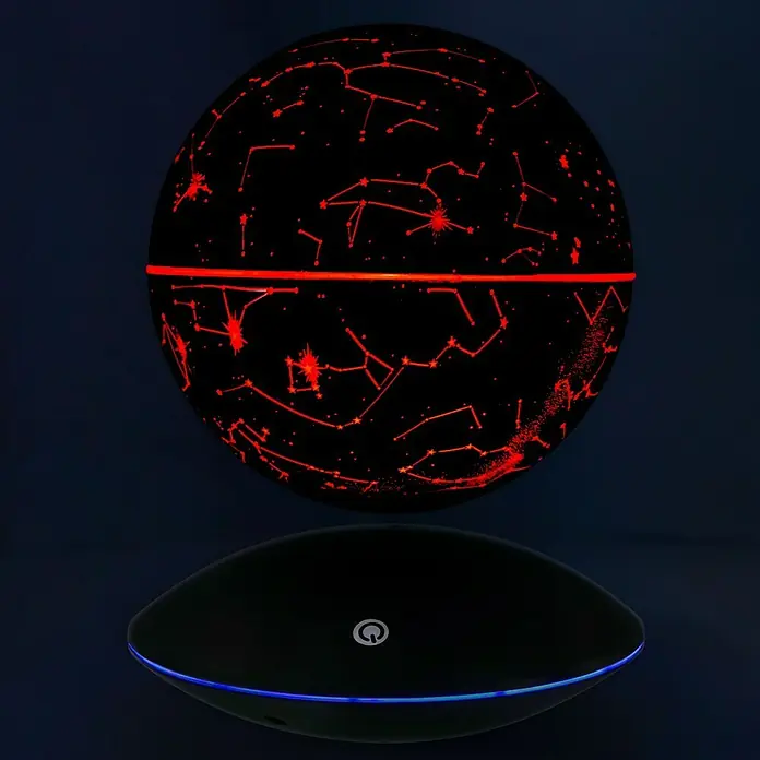 LED-Dekoleuchte rund Sternbilder - 3 W, Schwarz - Schwebender Globus mit Sternbildern, der durch rote Lichter hervorgehoben wird, ruht auf einer schwarzen Basis mit blauer Beleuchtung.