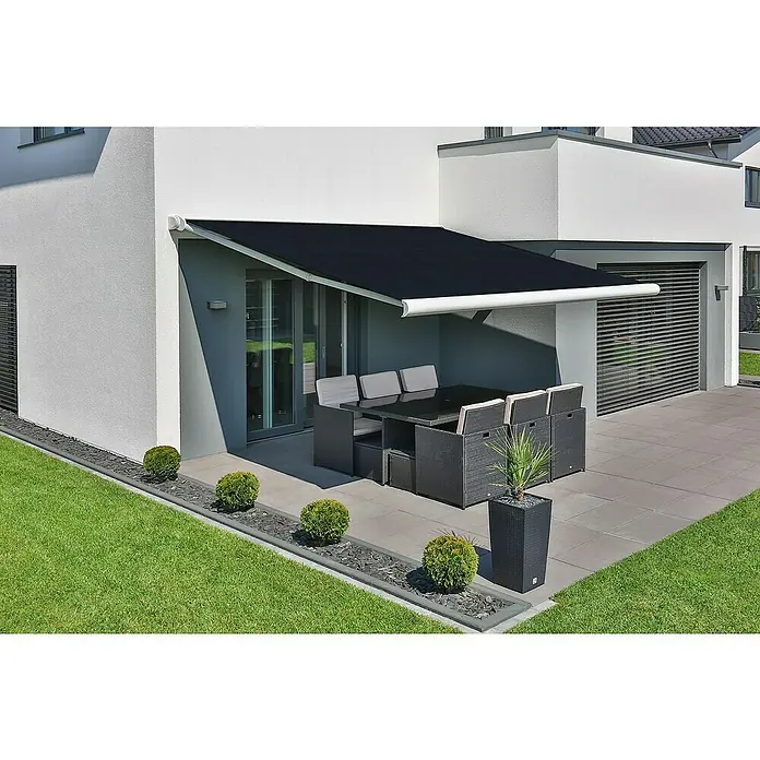 Deyo Limassol Vollkassettenmarkise - Dunkelgrau, Farbe Gestell: Signalweiß, Breite: 3,5 m, Ausfall: 3 m - Eine moderne, schwarze Markise spendet Schatten über einer Gartengarnitur auf einer Terrasse eines modernen Hauses.