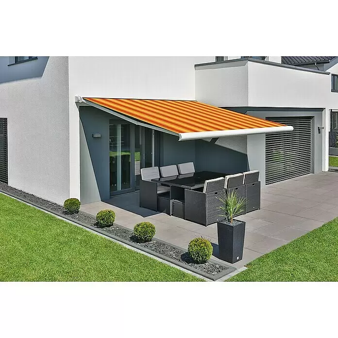 Deyo Limassol Vollkassettenmarkise - Orange/Gelb, Farbe Gestell: Signalweiß, Breite: 4 m, Ausfall: 3,5 m - Orange-gelb gestreifte Markise, ausgefahren über einer modernen Terrasse mit Gartenmöbeln, spendet Schatten.