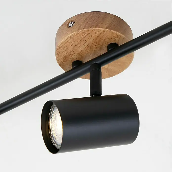 Briloner Muritz Regleta - 105 W, L x An x Al: 47,3 x 9 x 14,3 cm, Negro/Marrón, GU10, 3 ud. - Primer plano de una lámpara de techo moderna con base de madera y foco negro, que emite una luz cálida.