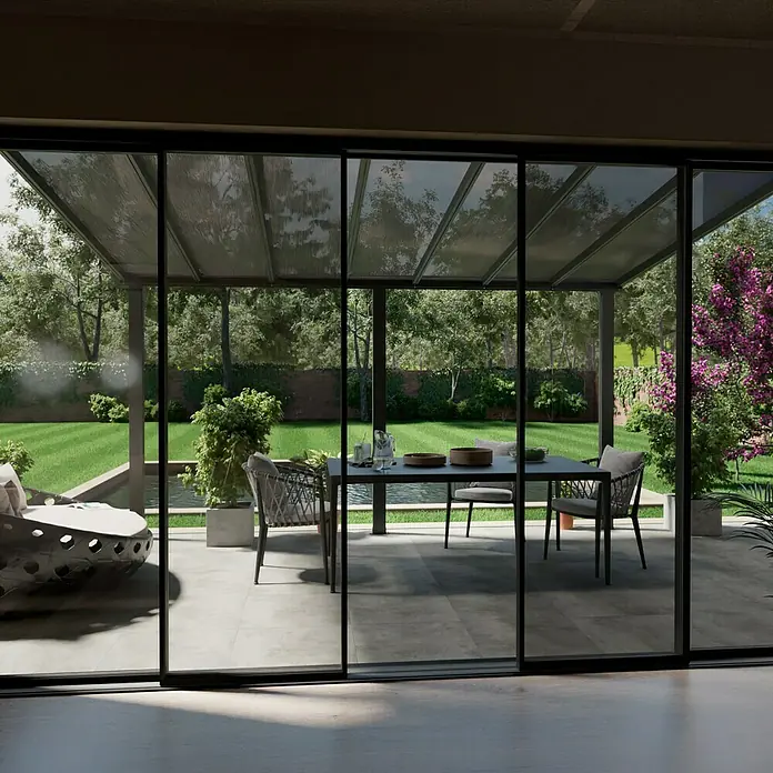 Gardendreams Terrassenüberdachung Comfort - B x T: 424 x 300 cm, Anthrazitgrau, Polycarbonat, Transparent - Ein stilvoller Outdoor-Essbereich mit modernen Gartenmöbeln, sichtbar durch große Glasschiebetüren, die den Innen- und Außenbereich verbinden.