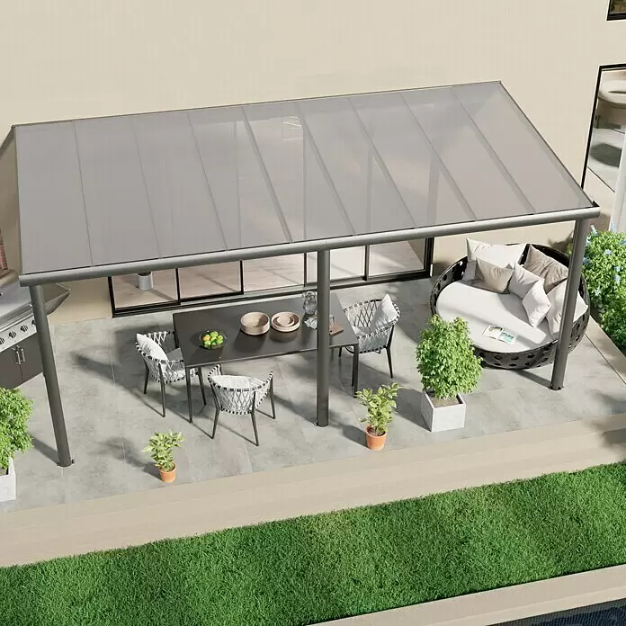 Gardendreams Terrassenüberdachung Comfort - B x T: 544 x 250 cm, Anthrazitgrau, Polycarbonat, Transparent - Graue Aluminium-Pergola mit lichtdurchlässigen Dachpaneelen, beschattet einen Ess- und Loungebereich im Freien.