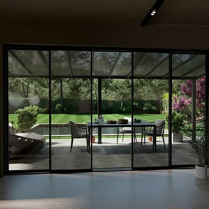 Gardendreams Terrassenüberdachung Comfort - B x T: 604 x 250 cm, Anthrazitgrau, Polycarbonat, Transparent - Ein modernes Glas-Wintergarten mit dunklen Rahmen, der einen Innenraum mit einem Garten und Essbereich verbindet.