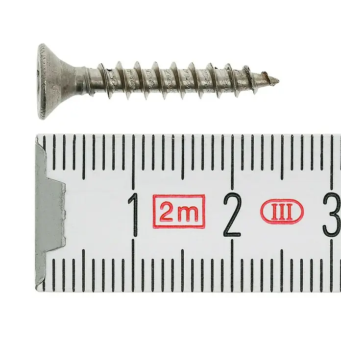 Profi Depot Spanplattenschraube A2 - Durchmesser: 4 mm, Länge: 25 mm, Edelstahl, TX für TORX-Antriebe, Vollgewinde, 200 Stk. - Nahaufnahme einer Schraube neben einem Messband, das die Länge der Schraube anzeigt.