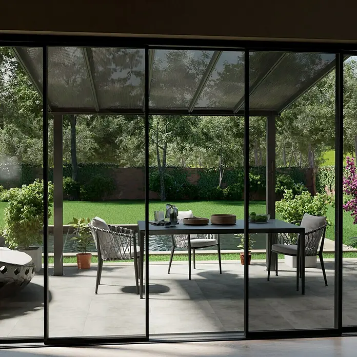 Gardendreams Terrassenüberdachung Comfort - B x T: 304 x 250 cm, Anthrazitgrau, Polycarbonat, Transparent - Einladende Terrassengestaltung mit Esstisch und Stühlen unter einer transparenten Überdachung, die den Blick in den grünen Garten freigibt.