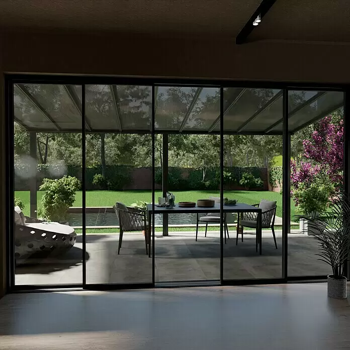 Gardendreams Terrassenüberdachung Comfort - B x T: 544 x 300 cm, Anthrazitgrau, Polycarbonat, Transparent - Moderne Terrassenüberdachung mit transparentem Dach und dunklen Rahmen, die einen Außenwohnbereich mit Blick auf einen üppigen Garten bietet.