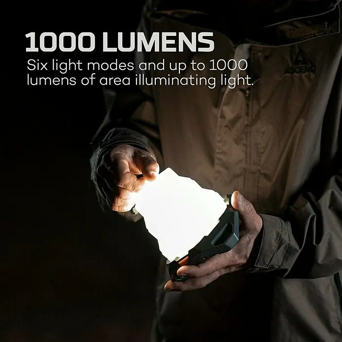 Nebo Tools Linterna Galileo Air - 12 x 12 x 11,8 cm, 40 lm - 1.000 lm, IPX4 - Primer plano de una luz LED de 1000 lúmenes con seis modos de luz sostenida por una persona en la oscuridad.