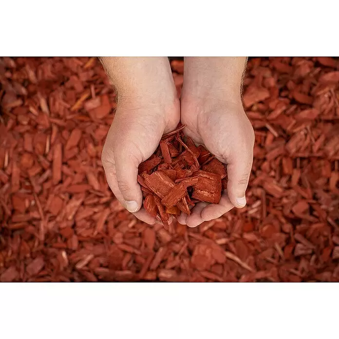 Bevermann Dekormulch - 50 l, Ziegelrot - Rote Holzspäne in gekrümmten Händen über einer Oberfläche weiterer roter Späne.