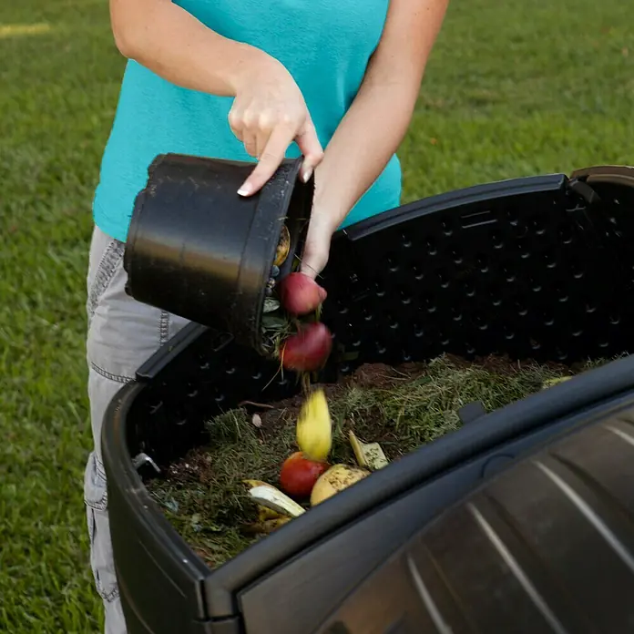 Lifetime Komposter Zwilling - 380 l, 80 x 148 x 111 cm - Frau, die eine schwarze Biokomposttonne im Garten leert. Kompostieren Sie Ihre Lebensmittelabfälle im Garten.