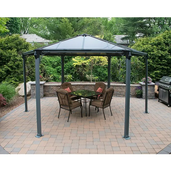 Palram – Canopia Pérgola estándar Mónaco - An x Pr: 390 x 450 cm, Color del armazón: Antracita, Aluminio - Elegante cenador gris con mesa y sillas en un patio pavimentado, perfecto para relajarse al aire libre.