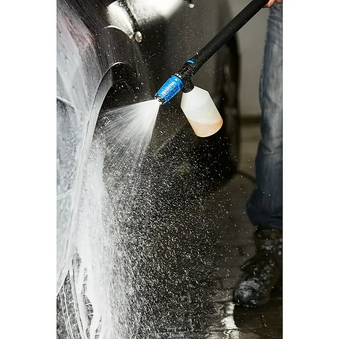 Nilfisk Hidrolimpiadora de alta presión CORE 140IH PCC - 140 bar, 1.800 W, Capacidad de bombeo: 474 l/h - Primer plano de un hombre limpiando un coche con un rociador de espuma, destacando el diseño del rociador y la aplicación de espuma densa en la superficie del vehículo.