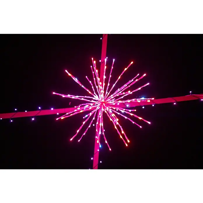 Twinkly LED-Dekoleuchte Spritzer - Netzbetrieben - Nahaufnahme einer rosafarbenen LED-Sternschnuppe, die an zwei sich kreuzenden rosa Bändern aufgehängt ist und eine festliche Atmosphäre schafft.