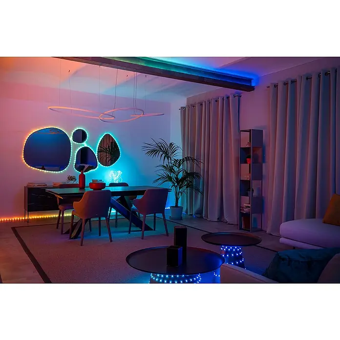 Twinkly Smart-LED-Band Dots - Länge: 10 m, RGB, 24 W, Schwarz - Das Bild zeigt ein Esszimmer mit LED-Beleuchtung, die die Spiegel, den Boden und die Tische hervorhebt, und eine moderne Einrichtung.