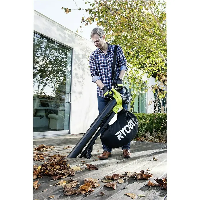 Ryobi ONE+ Akku-Laubsauger OBV18 - 18 V, Ohne Akku, Blasgeschwindigkeit: 201 km/h - Ein Mann benutzt einen Ryobi Laubbläser, um Blätter von einer Holzterrasse zu entfernen. Er trägt Schutzbrille und Handschuhe für Sicherheit.