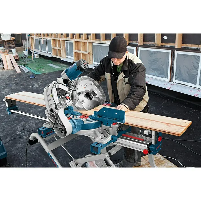 Bosch Professional Kapp- & Gehrungssäge GCM 12 GDL - 2.000 W, Durchmesser Sägeblatt: 305 mm, Leerlaufdrehzahl: 4.000 U/min - Ein Mann arbeitet mit einer Bosch Kapp- und Gehrungssäge GCM 8 SJL, um ein Holzbrett zu schneiden.