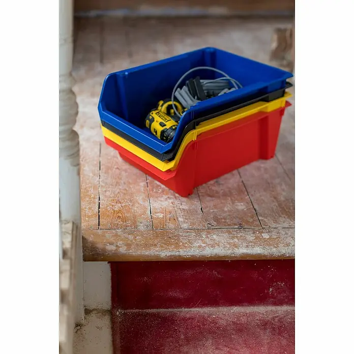 Stanley Gaveta - Tamaño: 5, Rojo - Una pila de contenedores de almacenamiento coloridos (azul, negro, amarillo, rojo) llenos de herramientas, ideales para la organización del taller y el almacenamiento de piezas pequeñas.