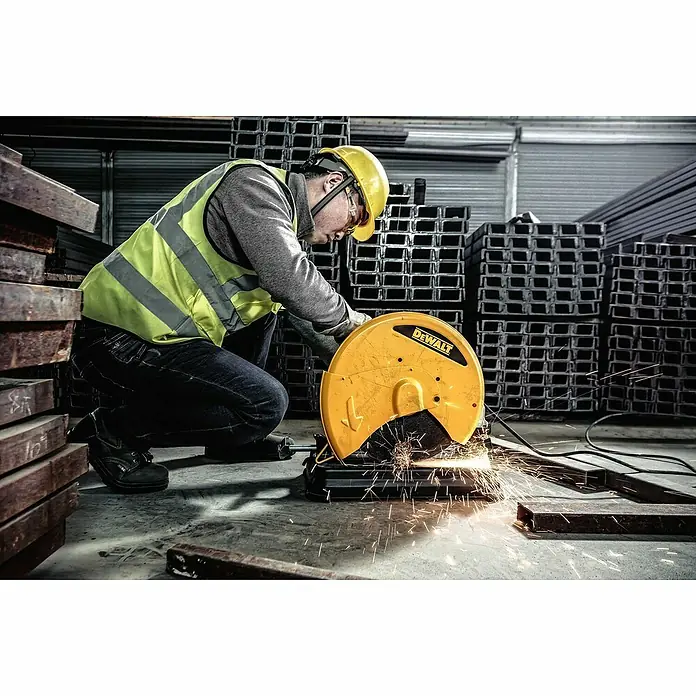 DeWalt Tronzadora D28730-QS - 2.200 W, Diámetro hoja de sierra: 355 mm, Número de revoluciones de marcha en vacío: 4.000 r.p.m. - Un trabajador de la construcción usa una tronzadora de metal amarilla DeWalt para cortar metal, con chispas.