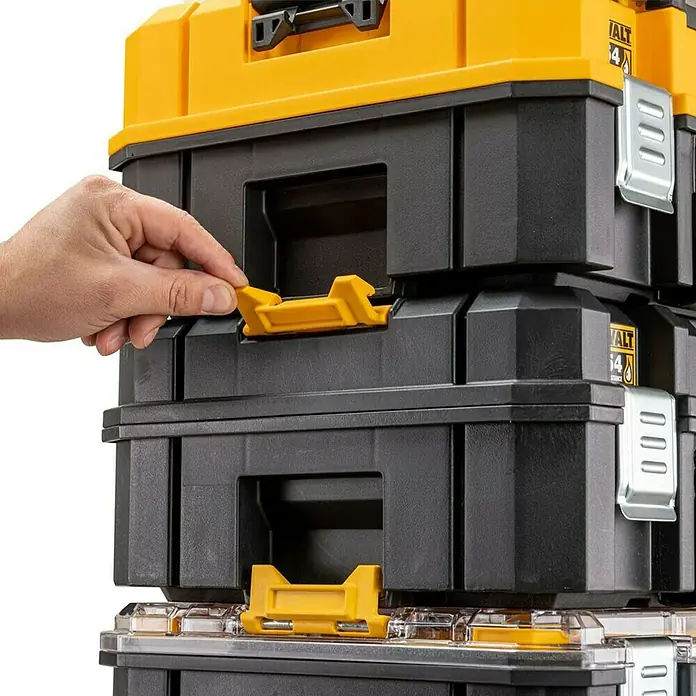 DeWalt T-STAK Werkzeugkoffer - L x B x H: 44 x 33,2 x 18,3 cm, Kunststoff, Traglast: 30 kg - Nahaufnahme von DeWalt Werkzeugkisten, die übereinander gestapelt sind. Eine Hand öffnet einen gelben Verschluss an einer der schwarzen Boxen.