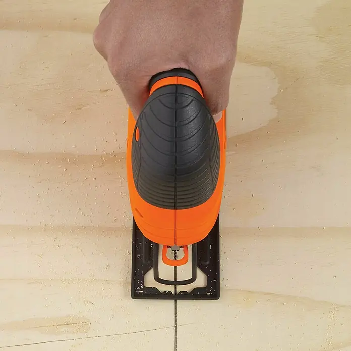 Black+Decker Caladora eléctrica KS701PEK-QS - 3.000 /min, Profundidad de corte máx. en madera: 70 mm, Número de niveles de elevación del péndulo: 4 ud. - Artesano cortando madera con una sierra de calar. La sierra corta con precisión a lo largo de una línea.