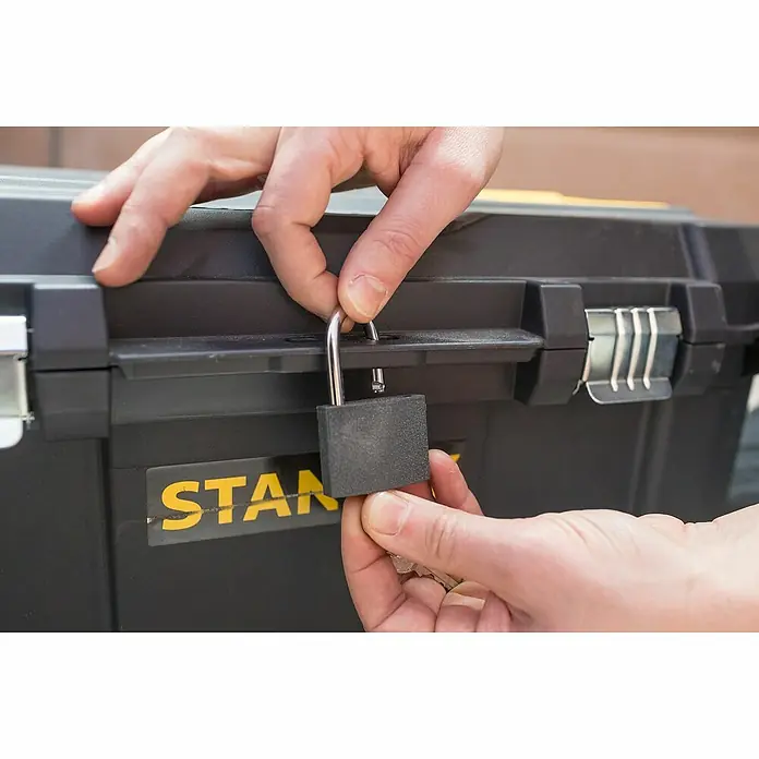 Stanley Caja para herramientas STST1-80150 - L x An x Al: 34,4 x 66,5 x 40,4 cm, Polipropileno, Capacidad volumétrica: 50 l - Se está cerrando una caja de herramientas negra Stanley con un candado para asegurar el contenido en su interior.